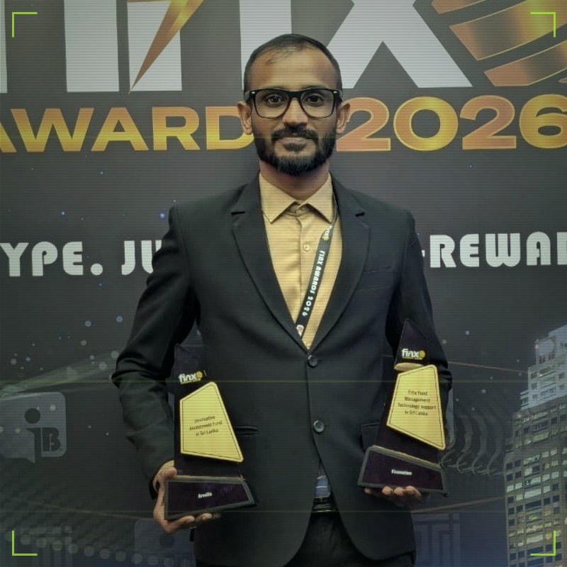 Mizhar Raja holding the two FinX Awards 2026 trophies on stage